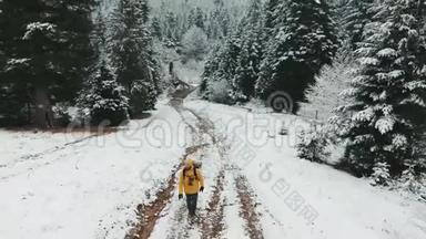 空中射击。 冬天，一个背着背包的人正在上山。 从白雪皑皑的小路上看着